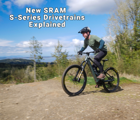 Person riding a mountain bike on a trail with trees in the background.